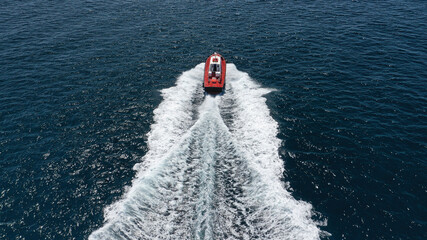 Aerial drone photo of red pilot boat cruising in high speed in Mediterranean deep blue sea offering...