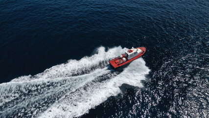 Aerial drone photo of red pilot boat cruising in high speed in Mediterranean deep blue sea offering...
