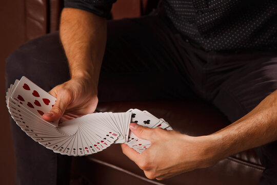 Clever Hands Of Magician On Black Background. Portrait Of Young Man With Gambling Cards. Handsome Guy Shows Tricks With Card. Concept Of Entertainment And Hobbies. Copyright Space