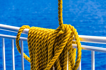 Yellow braided rope draped over a ship railing