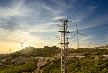 Wind-driven generators (wind generators), support of high-voltage power lines, wires, against the background of the sunshine sky