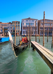 Fototapeta na wymiar Gondola moored by the pier on Grand Canal in Venice, Italy.