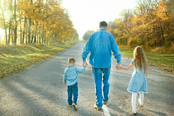 Fototapeta premium A Happy parent with child are walking along the road in the park on nature travel