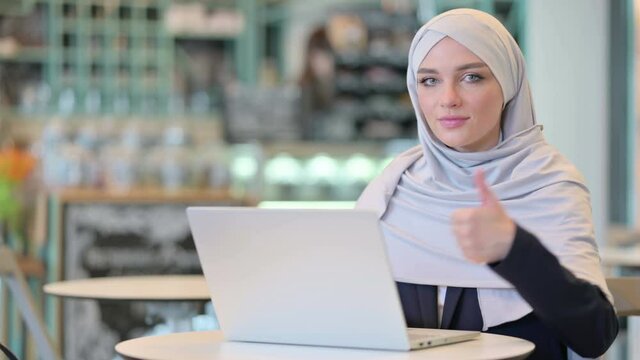 Thumbs up by Arab Woman Working on Laptop