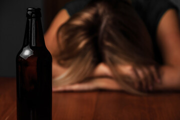 DRUNK WOMAN SITS NEXT TO A BOTTLE