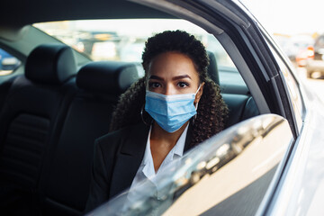 Young businesswoman took a taxi and having a ride as a passenger during covid-19 pandemic...