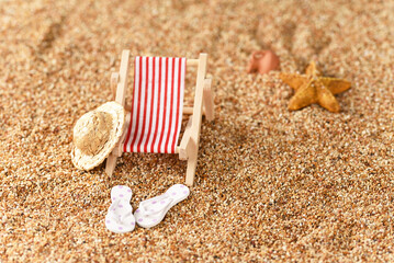 Fototapeta na wymiar Miniature sunbed on the beach, vacation in the sun.