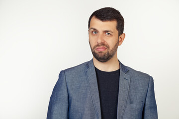 Young businessman man with a beard in a jacket, skeptical and nervous, frowning, upset because of the problem. Negative person. Portrait of a man on a gray background