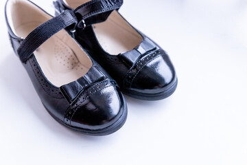 Fashionable black stylish girl's leather loafers on white background. Fashionable school shoes.Elegant kid's shoes