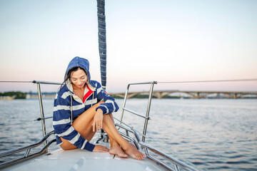 Beautiful girl resting on a yacht at sunset