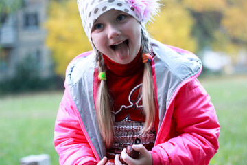 girl in red clothes makes faces and smiles