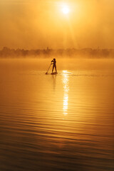 Muscular man on distance paddling on sup board