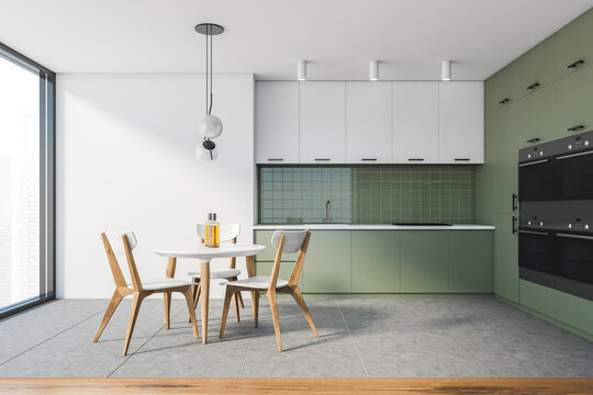 Modern white and green kitchen with dining table