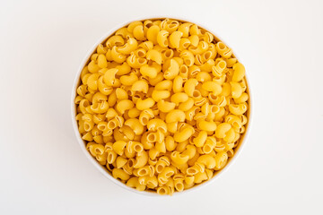 Raw dry uncooked Mini pipe rigate pasta spaghetti noodle on white bowl wooden background for basil tomato pesto sauce Homemade Italian food organic whole wheat vegan spaghetti for a healthy meal
