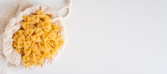 Raw dry uncooked Farfalle pasta spaghetti noodle on white bowl wooden background for basil tomato pesto sauce Homemade Italian food organic whole wheat vegan spaghetti for a healthy meal