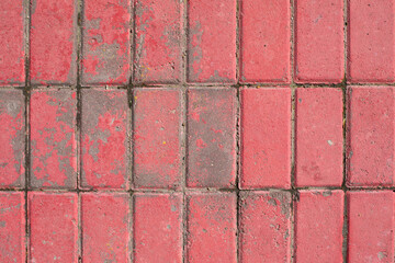 The texture of the paved road surface, the surface of the old red brick. Textured effect, weathered footpath, background backdrop design