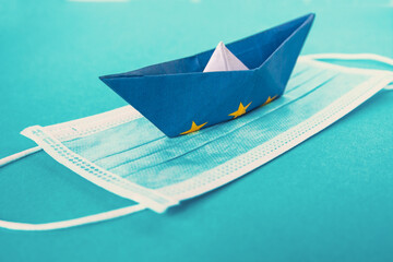 paper boat from the EU flag on a medical face mask.