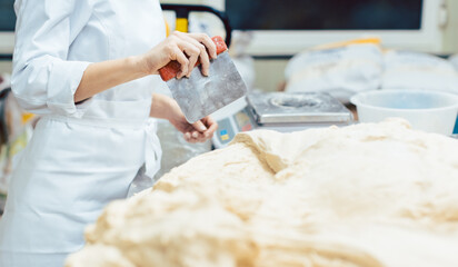Baker measuring dough to make a bread