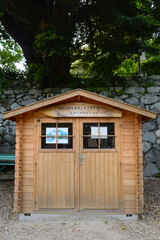 A small shelter at Mount Tsukuba with a sign written in Japanese translated as "Tsukuba Tourism Volunteer Guide, Mount Tsukuba Shrine Information"