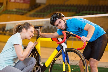 Obraz premium female coach speaking with cyclist on velodrome track