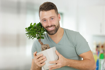 happy man takes care of indoor plants