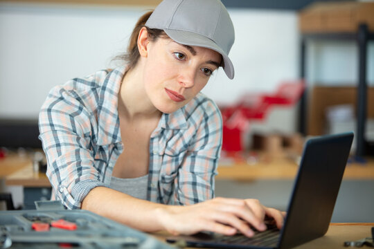 female mechanic using laptop at workplace