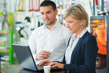warehouse managers working together on laptop in a large warehouse
