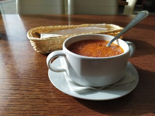 White ceramic bowl with borsch soup on a wooden table
