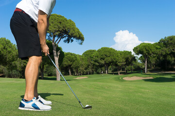 Male golf player with golf club on professional golf course