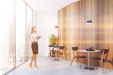 Fototapeta premium Young woman in white and wooden restaurant