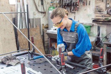 woman in Metal workshop with tools and workpiece