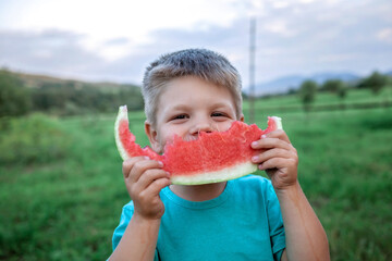 Healthy summer food. Cute kid biting a slice of watermelon in the backyard of farmhouse