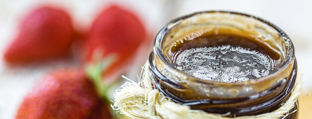 organic strawberry jam on rustic white wooden table, spot focus