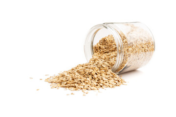 Fallen oat flakes from a jar isolated on white background