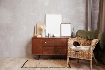 Minimalistic composition of sitting room interior with wicker rattan armchair and wooden cabinet...