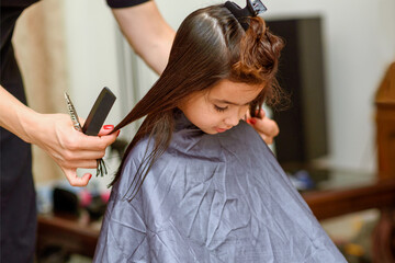Little Girl Having Her Hair Cut. Little Girl Sitting In Beauty Hair Salon Style For Children.