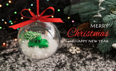 Congratulation of merry christmas and new year on the background of a transparent ball with a toy...