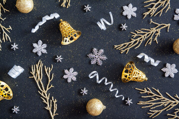 Obraz na płótnie Canvas Top view Merry Christmas black background decorated with Happy New Year Christmas garlands, snowflakes, golden bells. Winter holiday pattern