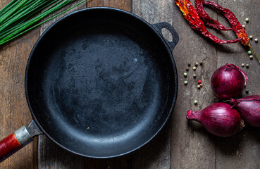 pan on wooden table with vegetables