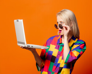 Style blonde in 90s clothes with notebook computer