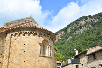 Fototapeta na wymiar BEGET, CATALONIA, SPAIN, EUROPE, SEPTEMBER 2020. Fantastic Romanesque church of San Cristóbal with a window in the rear vault and surrounded by stone houses in the beautiful medieval town of Beget