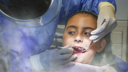 Young caucasian girl caring about her teeth. Portrait of charming girl sitting in dentist chair