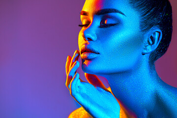 High Fashion model woman in colorful bright sparkles and neon lights. Beauty face, portrait of...