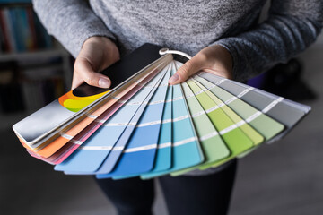 Close up on hands of unknown female person holding color palette at home in apartment - Woman...
