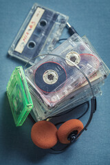 Old stack of audio cassettes with orange headphones