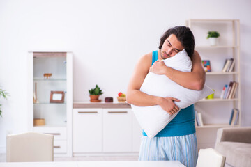Young man waking up at home
