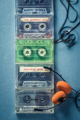 Top view of several cassette tapes with orange headphones