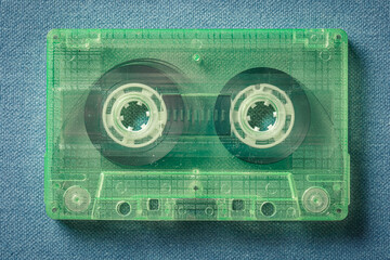 One green audio cassettes on blue sofa