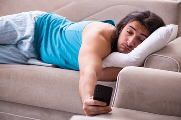 Young man waking up at home