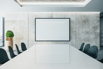 Meeting interior with long conference table and  projector screen on wall.